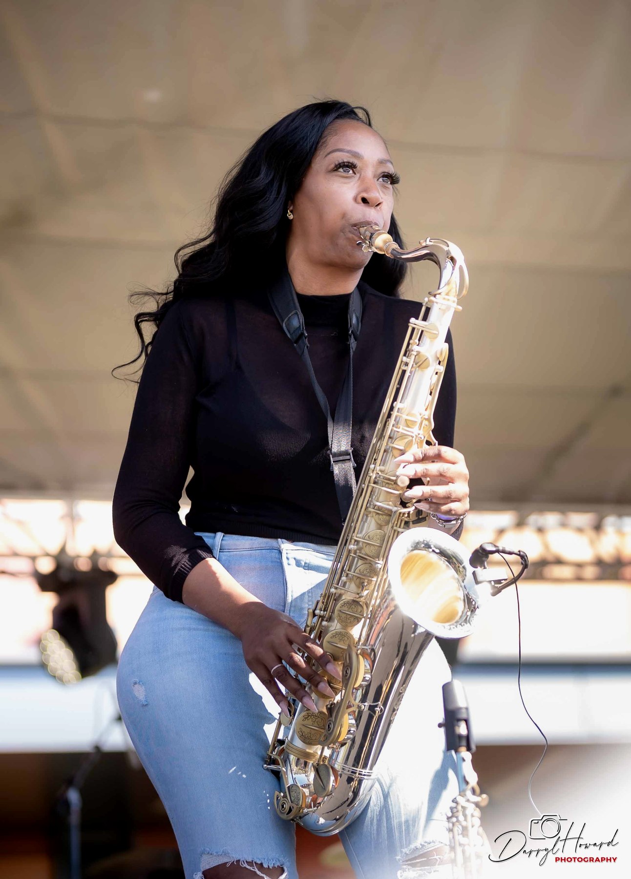 Charmin performing saxophone at an outdoor festival